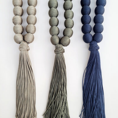 Sautoir composé de perles textile façonnées à partir de fil de soie végétale se terminant par un pompon fluide. Création artisanale marocaine.